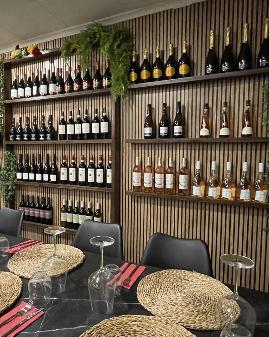 Pared de vinos italianos del Ristorante Senza Fretta, con estantes de madera